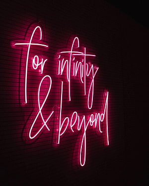 Pink Cursive Neon Sign Reading For Infinity And Beyond On Dark Brick Wall HD phone wallpaper