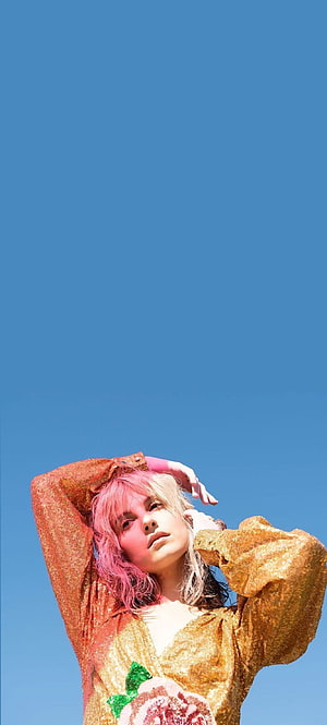Hayley Williams in a gold sequined top with pink hair against a clear blue sky HD phone wallpaper