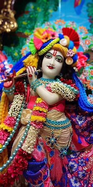 Ornate Radha Krishna Idol Adorned With Vibrant Floral Garlands And Traditional Jewelry HD phone wallpaper