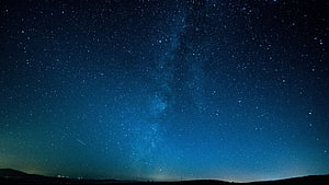Milky Way Galaxy Arching Over Dark Horizon Under a Deep Blue Starry Night Sky HD wallpaper