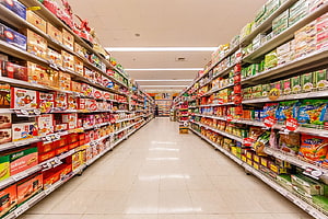 Brightly Lit Supermarket Aisle Packed With Colorful Grocery Products HD wallpaper