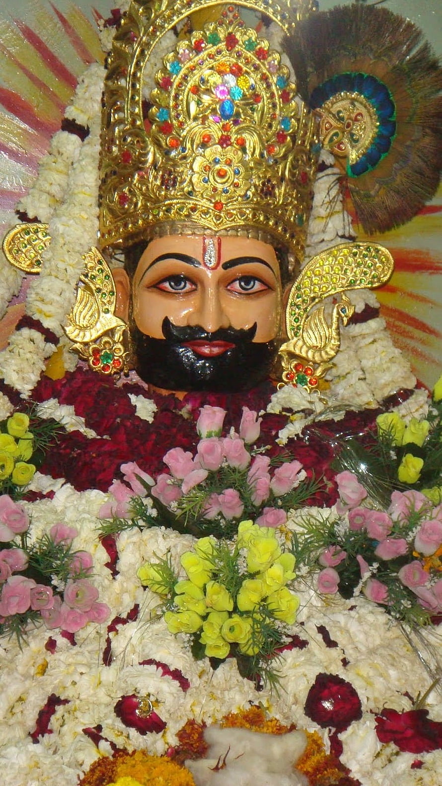 Khatu Shyam Ji adorned with vibrant floral garlands and ornate golden crown HD phone wallpaper