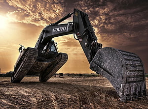 Volvo Heavy Excavator at Sunset in a Construction Site HD wallpaper