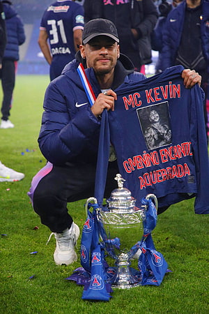 MC Kevin Kneeling with PSG Trophy and Custom Jersey on the Pitch HD phone wallpaper