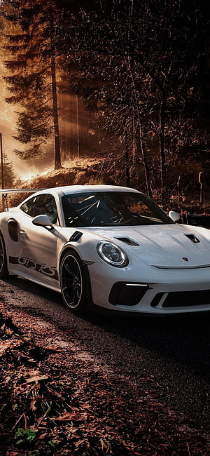 White Porsche 911 GT3 RS parked on a forest road at golden hour with dramatic backlighting HD phone wallpaper