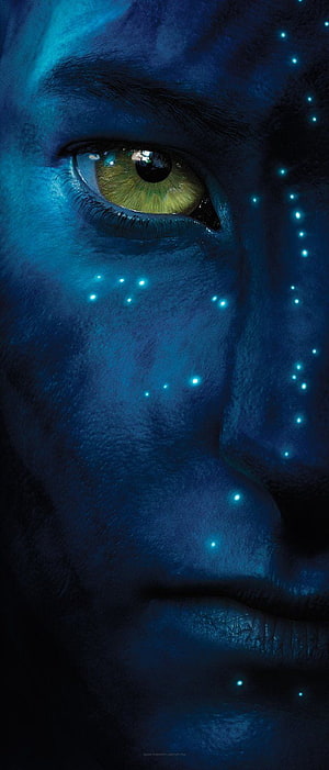 Close-up of a blue-skinned Na'vi face with glowing bioluminescent dots and a striking green eye from the Avatar film HD phone wallpaper