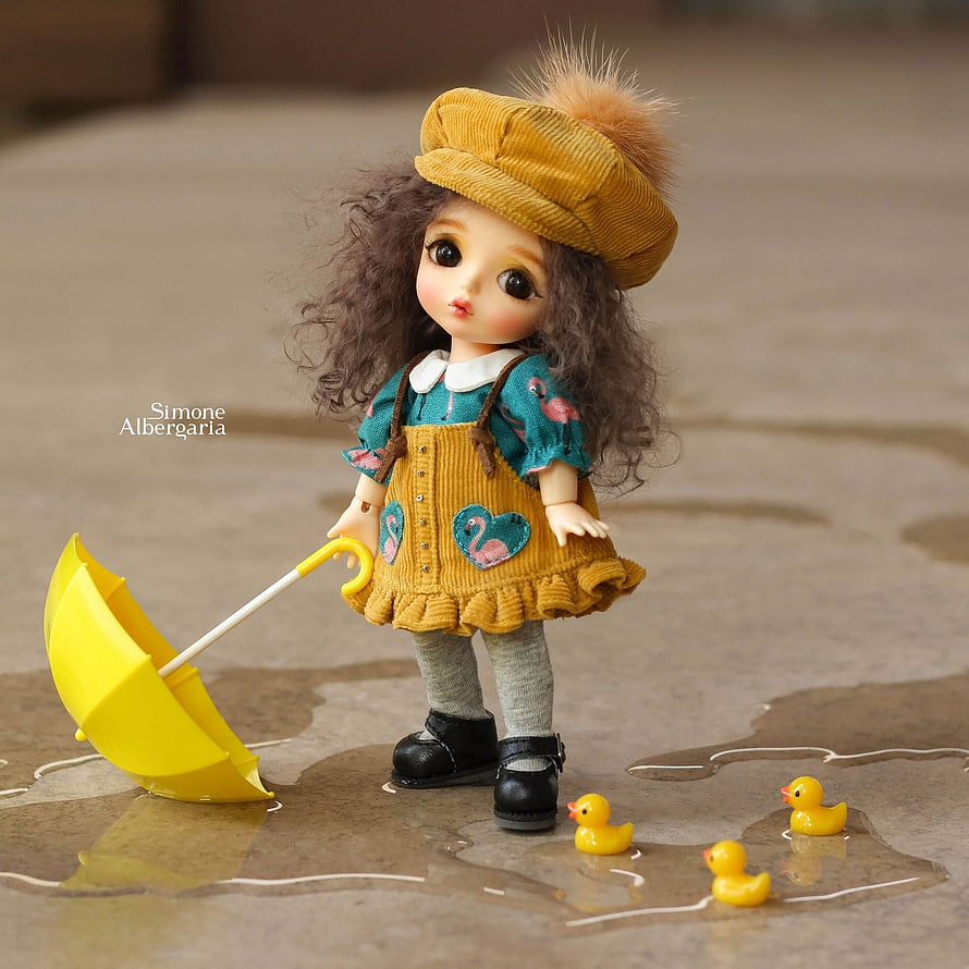 Cute BJD Doll in Yellow Corduroy Outfit with Umbrella and Rubber Ducks in Rain Puddle HD phone wallpaper