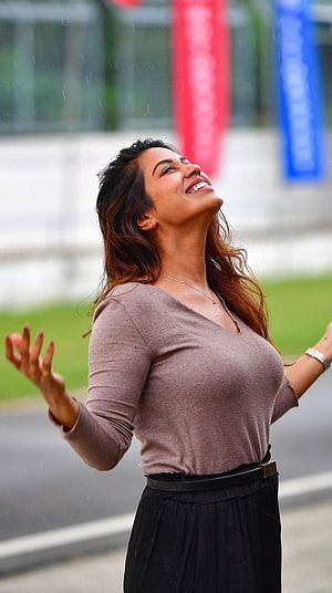 Nivetha Pethuraj Smiling Joyfully in the Rain with Arms Outstretched HD phone wallpaper