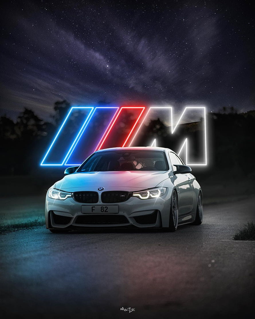 White BMW M4 Coupe with Neon M Logo Under Starry Night Sky HD phone wallpaper