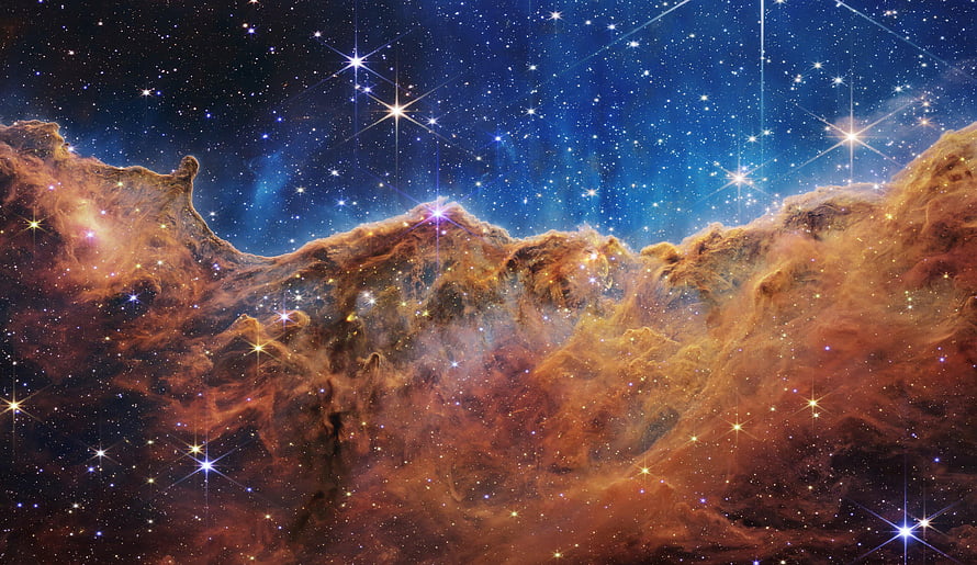 Carina Nebula in Vibrant Orange and Blue Hues Captured by the James Webb Space Telescope HD wallpaper