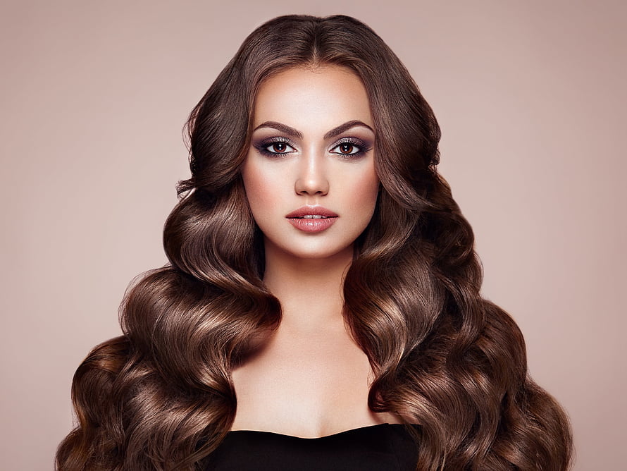 Studio Portrait of a Woman with Voluminous Brown Curls and Dramatic Makeup HD wallpaper