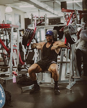 Chris Bumstead Performing Seated Chest Press in a Commercial Gym HD phone wallpaper