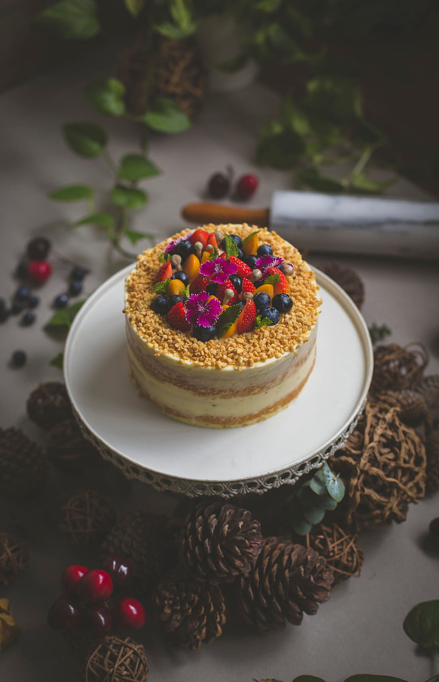 Rustic Naked Cake Topped With Fresh Berries And Edible Flowers On A White Cake Stand HD phone wallpaper