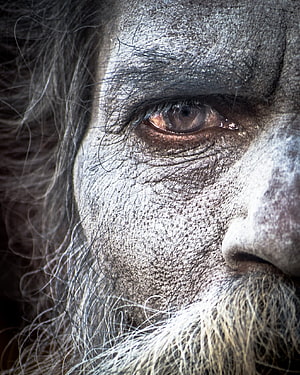 Close-up portrait of an Aghori with ash-covered face and intense gaze HD phone wallpaper