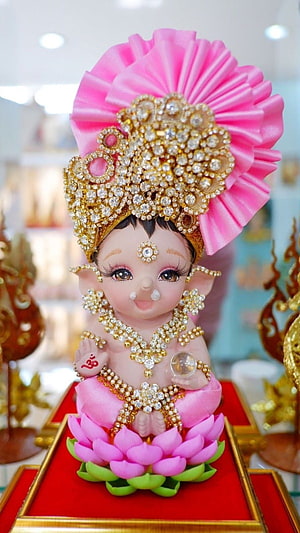 Ornate Baby Ganesha Idol Seated on Pink Lotus with Crystal Crown and Gold Jewelry HD phone wallpaper
