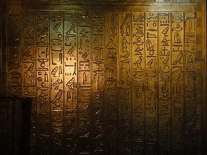 Ancient Egyptian Hieroglyphic Wall Carving with Golden Illumination HD wallpaper