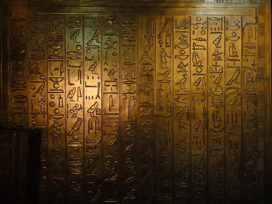 Ancient Egyptian Hieroglyphic Wall Carving with Golden Illumination HD wallpaper