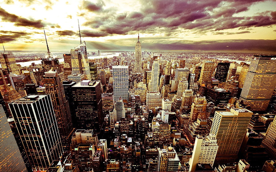 Aerial View of New York City Skyline at Dusk with Dramatic Clouds and Golden Light HD wallpaper