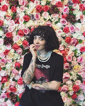 Mon Laferte Portrait in Front of a Vibrant Rose Wall Wearing a Black T-Shirt and Pearl Necklaces HD phone wallpaper