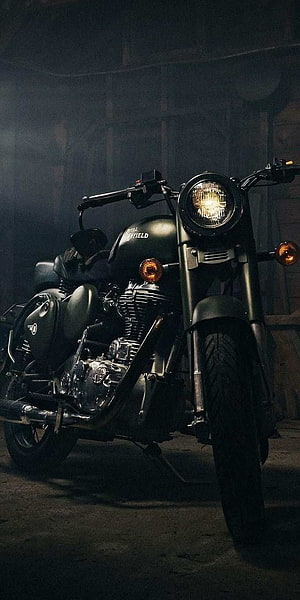 Royal Enfield Bullet Standard motorcycle in a dimly lit garage with dramatic lighting HD phone wallpaper