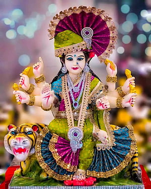 Ornate Durga Puja idol with eight arms, tiger mount, and festive jewelry HD phone wallpaper