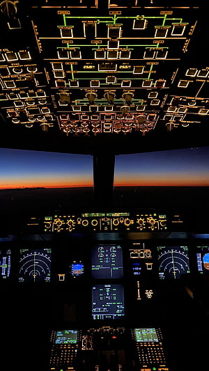 Boeing 747 Cockpit Interior at Sunset with Glowing Instrument Panels and Flight Displays HD phone wallpaper