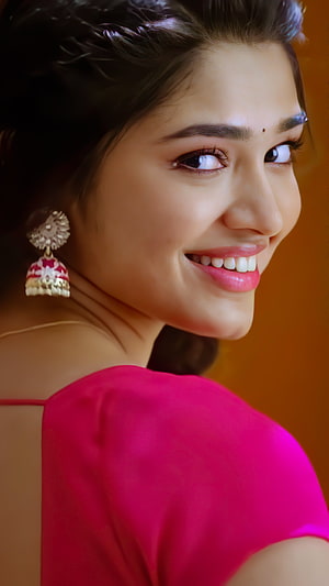 Kriti Shetty smiling portrait in vibrant pink attire with traditional jhumka earrings HD phone wallpaper