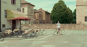 Call Me By Your Name Film Still: Young Man With Bicycle In Italian Town Square HD wallpaper