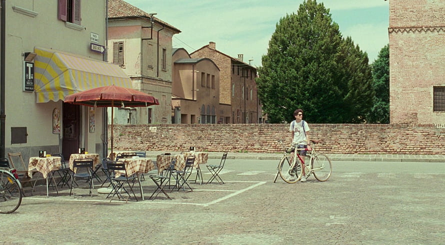 Call Me By Your Name Film Still: Young Man With Bicycle In Italian Town Square HD wallpaper