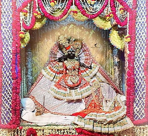 Ornate Banke Bihari Krishna Idol Adorned in Traditional Temple Garments and Floral Decorations HD wallpaper