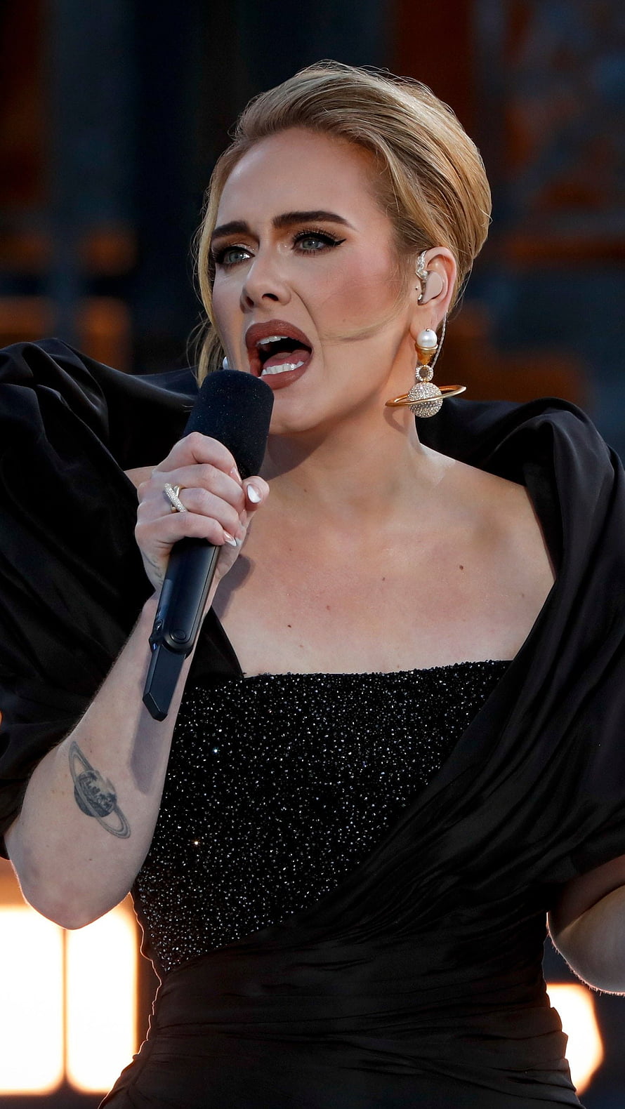 Adele performing live on stage in a black sequined gown with dramatic earrings HD phone wallpaper