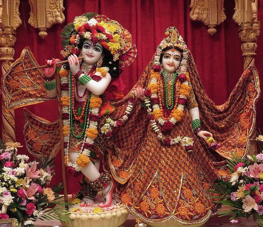 Radha Krishna Temple Idol in Ornate Wedding Attire with Floral Garlands and Marigold Decorations HD wallpaper