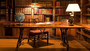 Classic Home Library Study With Wooden Desk, Antique Books, And Warm Lamp Lighting HD wallpaper