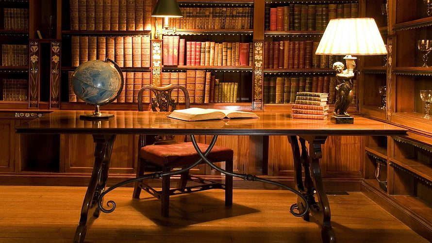 Classic Home Library Study With Wooden Desk, Antique Books, And Warm Lamp Lighting HD wallpaper