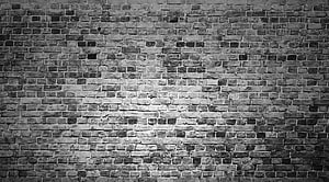 Monochrome Brick Wall Texture With Dramatic Central Lighting And Weathered Surface Details HD wallpaper