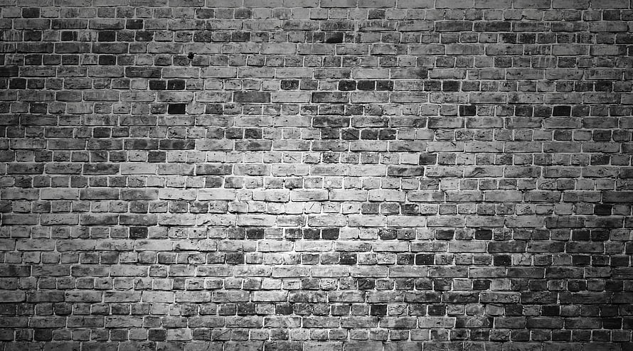 Monochrome Brick Wall Texture With Dramatic Central Lighting And Weathered Surface Details HD wallpaper