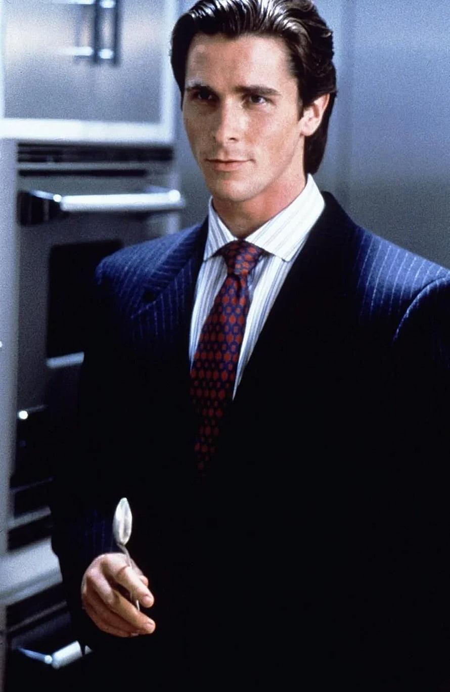 Patrick Bateman in a dark pinstripe suit holding a spoon in a modern kitchen, American Psycho , Patrick Bateman HD phone wallpaper