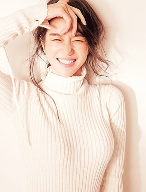 Seo Ye-ji smiling in a cream turtleneck sweater with hand on forehead HD phone wallpaper