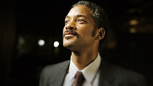 Will Smith in a formal suit gazing upward with a hopeful expression against a dark background HD wallpaper