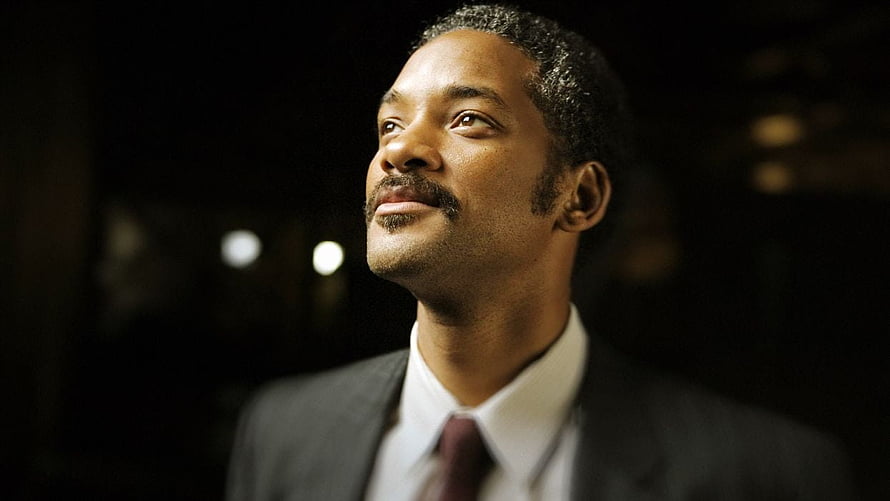 Will Smith in a formal suit gazing upward with a hopeful expression against a dark background HD wallpaper