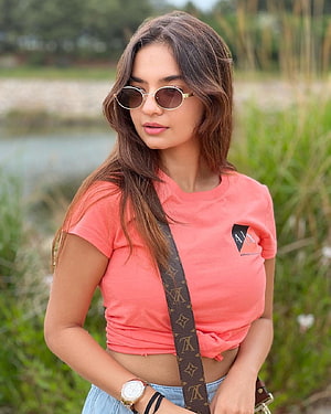 Anushka Sen Wearing Round Sunglasses and a Coral T-Shirt in a Natural Outdoor Setting HD phone wallpaper