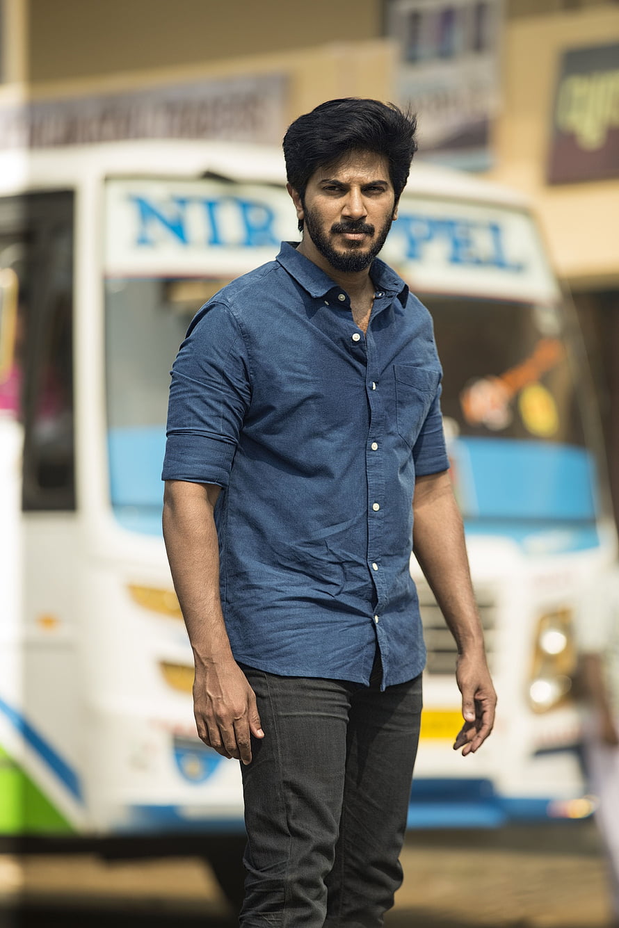 Dulquer Salmaan in Blue Shirt Standing in Front of a White Bus HD phone wallpaper