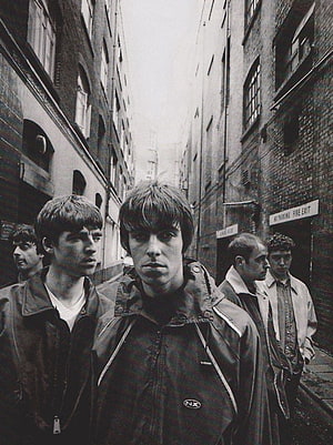 Oasis Band Members Walking Through a Narrow Urban Alley in Black and White HD phone wallpaper