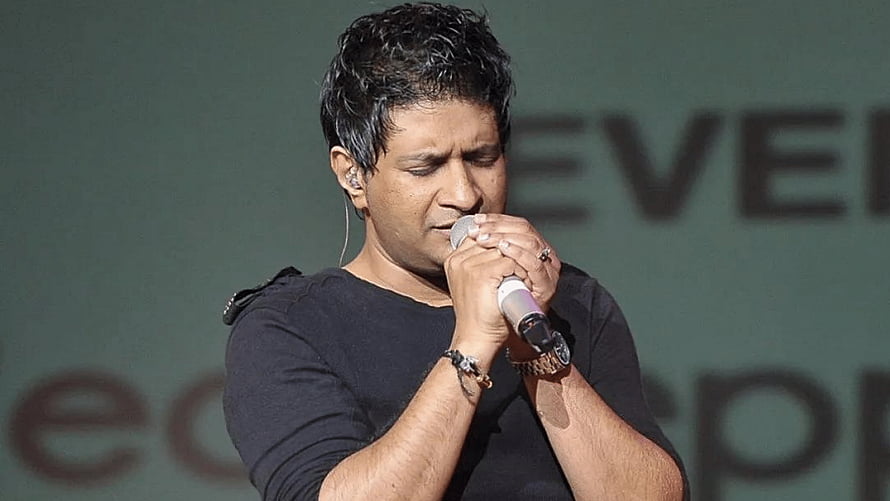 Krishnakumar Kunnath performing live on stage with microphone HD wallpaper