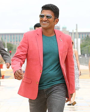 Puneeth Rajkumar in a coral blazer and teal shirt with aviator sunglasses HD phone wallpaper
