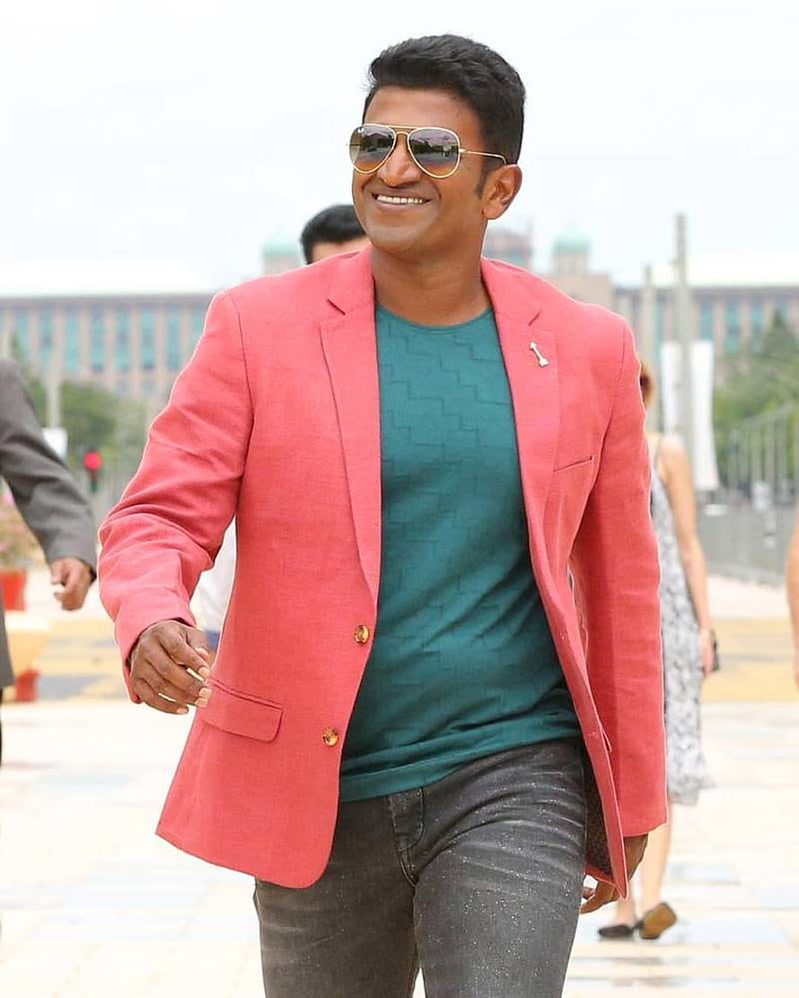 Puneeth Rajkumar in a coral blazer and teal shirt with aviator sunglasses HD phone wallpaper