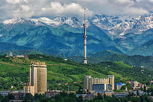 Almaty Cityscape with Snow-Capped Mountains and Tower in Kazakhstan HD wallpaper