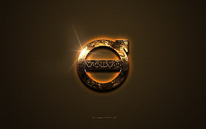 Volvo Emblem with Golden Glow on Dark Textured Metal Surface HD wallpaper