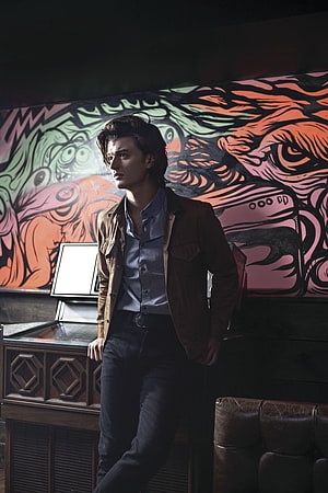 Joe Keery as Steve Harrington in Stranger Things with vibrant mural backdrop HD phone wallpaper
