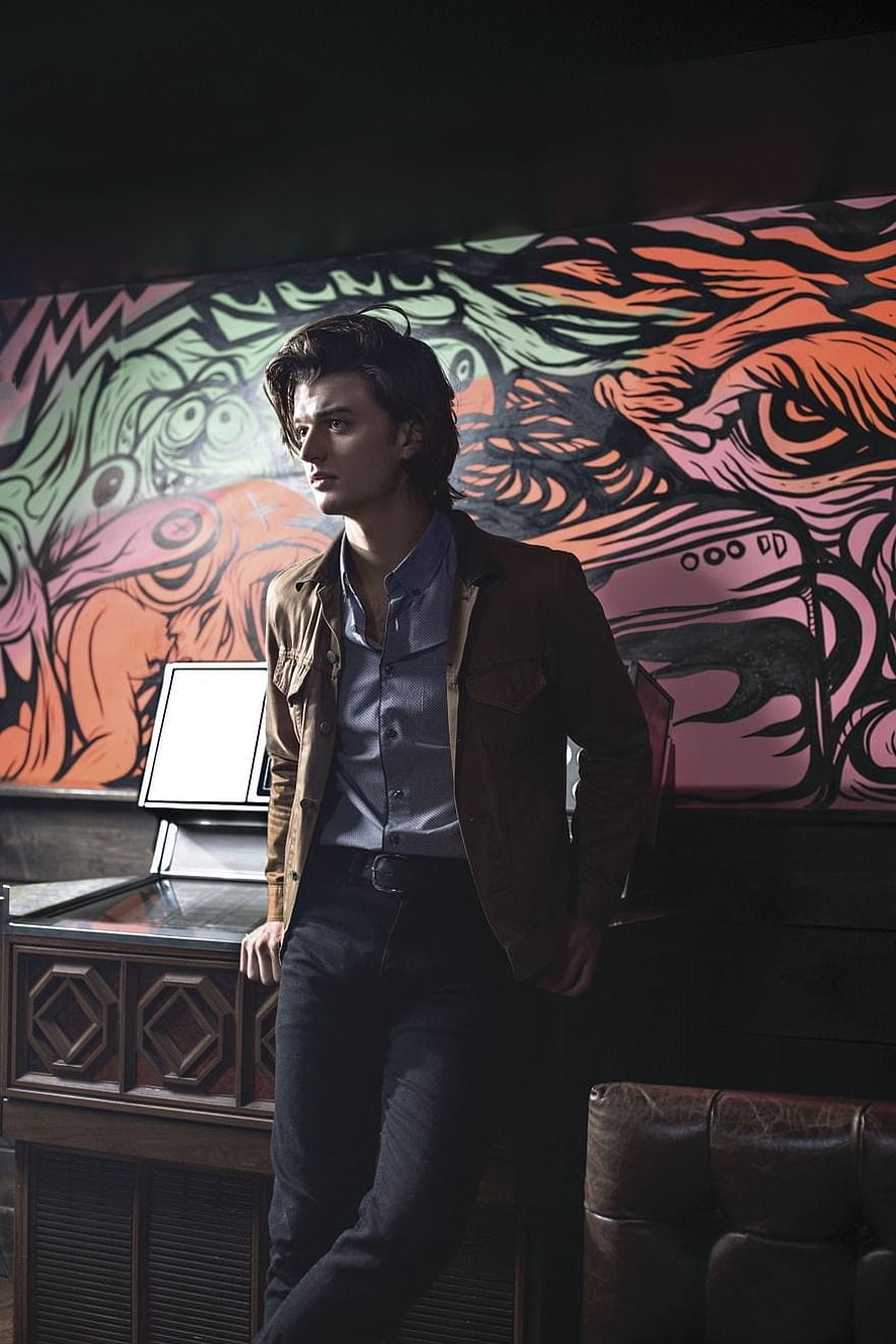 Joe Keery as Steve Harrington in Stranger Things with vibrant mural backdrop HD phone wallpaper